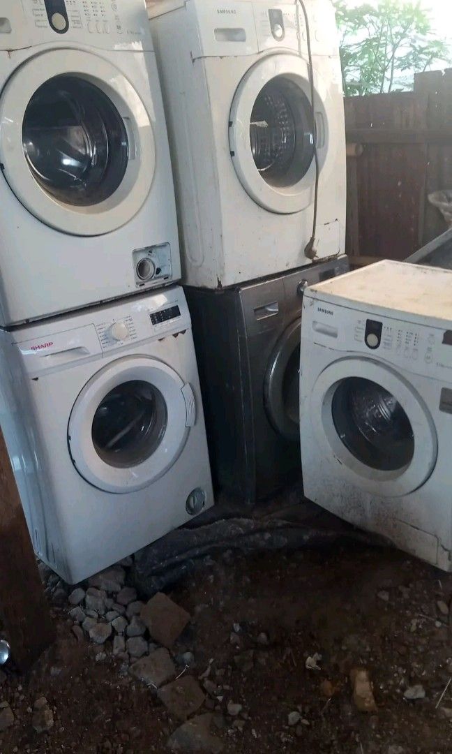 Mesin cuci rusak yang sedang diperbaiki teknisi